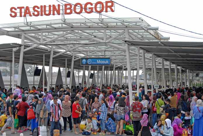 Calon penumpang kereta api Commuter Line antre masuk stasiun Besar Bogor, di Kota Bogor, Jabar, Minggu (19/7)