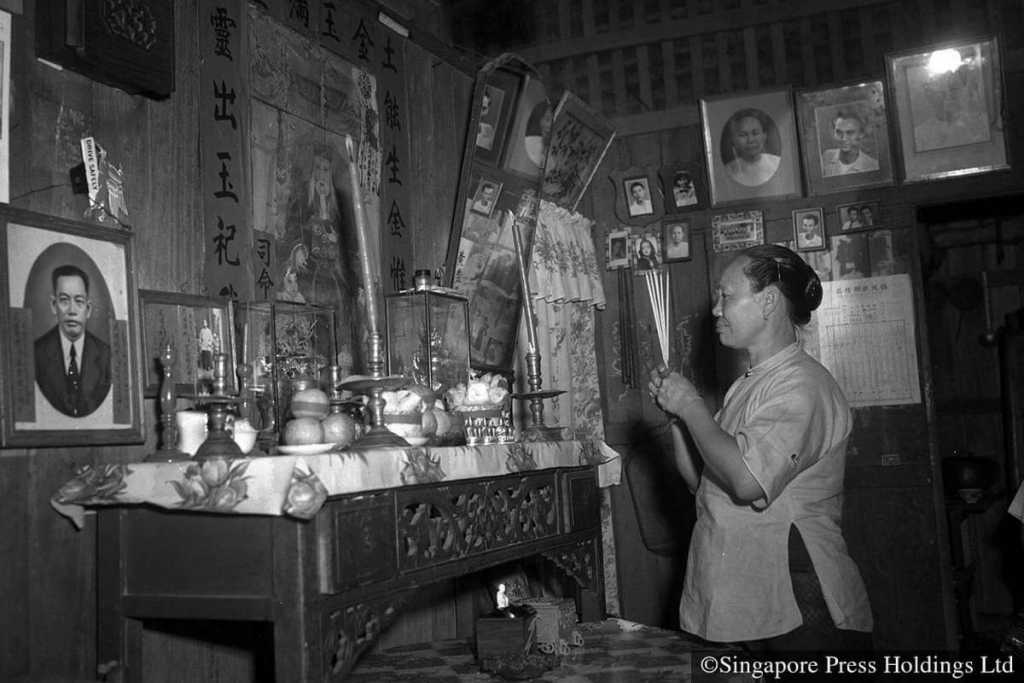 1954: Seorang wanita berdoa di depan altar keluarganya. Keluarga biasanya berdoa kepada nenek moyang mereka di kuil keluarga sebelum mereka duduk untuk makan malam reuni.