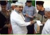 Bupati Karimun, H Aunur Rafiq saat menyerahkan bantuan ke pengurus Masjid Ar Rahman desa Tulang Karimun