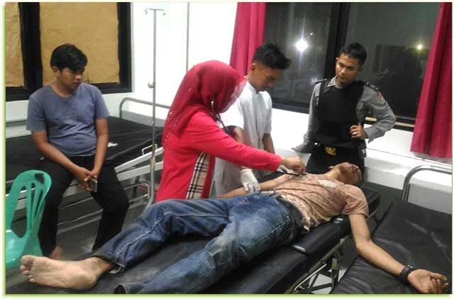 Pelaku berinisial L di UGD Puskesmas Tanjungbatu, saat sedang dirawat, yang dikawal petugas Polsek Kundur, (11/11).