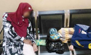 Ibu dan seorang anak yang tertidur diduga lelah, di ruang tunggu DISDUK CAPIL Karimun.