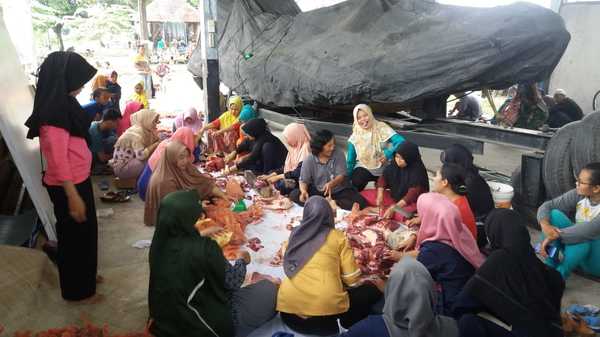 Ibu-ibu istri prajurit bersama masyarakat dalam membagi bagi daging sehingga siap dibagikan, Rabu (22/08/18).