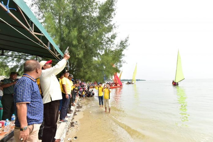 Bupati Karimun Aunur Rafiq melepaskan tembakan sebagai tanda dimulainya Festival Sampan Layar Tanjung Ambat Cup di Pantai Tanjung Ambat Kecamatan Buru, Minggu (23/12)