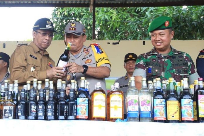 Kapolres Karimun AKBP Hengky Pramudya menunjukkan kemasan miras sebelum dimusnahkan, Jumat (21/12) di Mapolres Karimun.