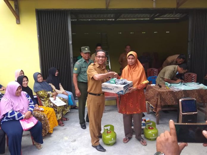 Sekcam Ungar, Heri Furwandi menyerahkan bantuan gas subsidi LPG 3 kilogram kepada masyarakat penerima di Desa Sungai Buluh, Selasa (8/1)