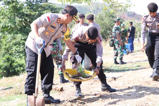 Kapolres Karimun AKBP Hengky Pramudya ikut membersihkan sampah yang berserakan di sekitar TPA Sememal Kelurahan Pasir Panjang Kecamatan Meral Barat