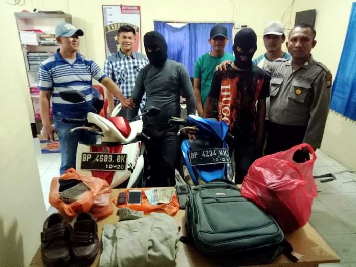 Dua pelaku pencurian, SP dan HR, bersma tim gabungan Unit Reskrim Polsek Kundur, dan sejumlah barang bukti