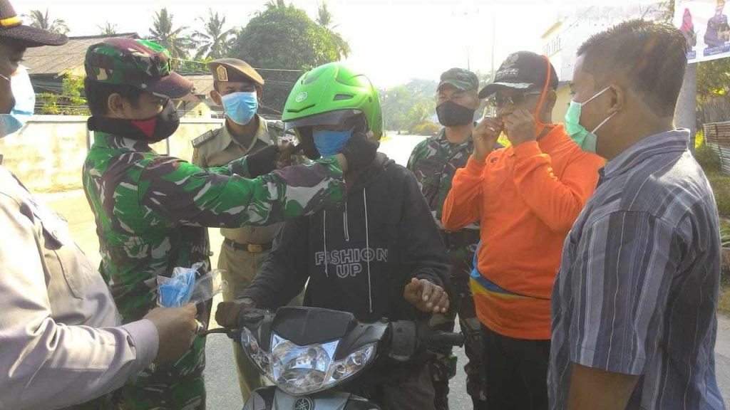 Anggota Koramil 03 Kundur saat mengenakan masker kepada pengendara