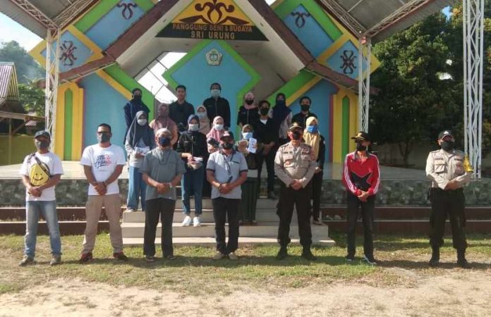 Anggota Polsek Kuba dan relawan HIMK usai membagi-bagikan masker di tugu Nenas Tanjungberlian, Ahad (19/04/2020). Anggota Polsek Kuba dan relawan HIMK usai membagi-bagikan masker di tugu nenas Tanjungberlian