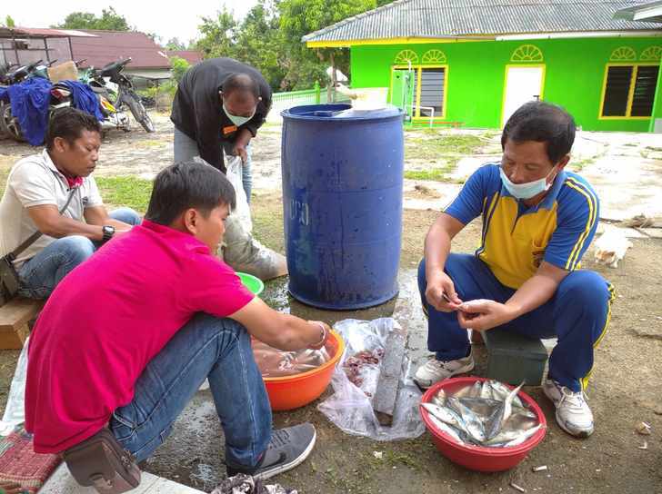 Kapolsek Kundur, Kompol Endi Endarto, saat bersihkan ikan di Dapur Umum Mapolsek Kundur, Peduli dampak Covid-19, Selasa, (14/04/2020).