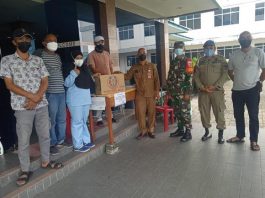 Ery Suandi saat menyerahkanbantuan susu encer beruang di isolasi terpusat, hotel Gembira Tanjungbatu