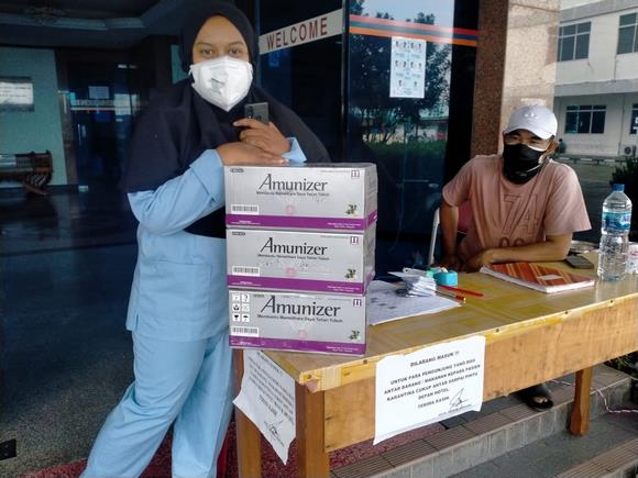 Mona, Kordinator Isolasi Terpusat, saat menerima bantuan Amunizer