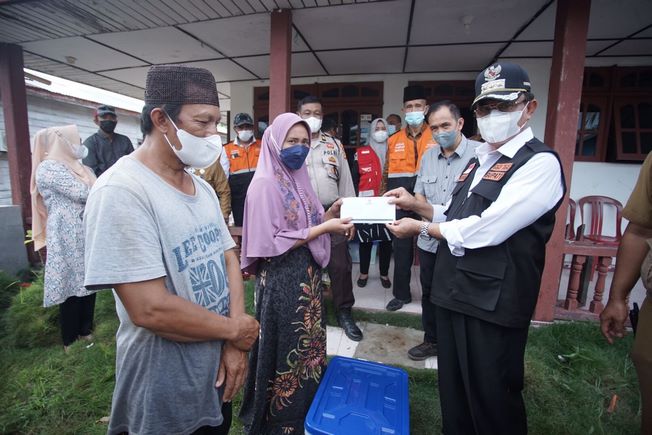 Bupati Inhil saat menyerahkan bantuan kepada korban tanah longsor di Desa Teluk Dalam