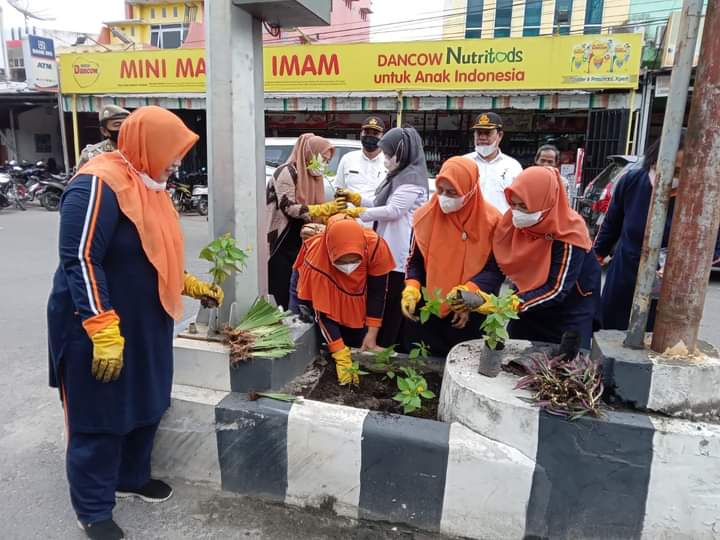 Ketua PKK Asahan bersama pengurus PKK lainnya sedang menanam Bunga di Jl Cokroaminoto Kisaran didampingi oleh Aparatur Dinas Lingkungan Hidup Kab. Asahan