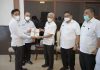 Kepala BPN Kabupaten Asahan menyerahkan sertifikat kepada Bupati Asahan yang didampingi oleh Sekda Kabupaten Asahan, Asisten III Pemkab Asahan dan Kepala BKAD Kabupaten Asahan