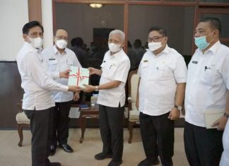 Kepala BPN Kabupaten Asahan menyerahkan sertifikat kepada Bupati Asahan yang didampingi oleh Sekda Kabupaten Asahan, Asisten III Pemkab Asahan dan Kepala BKAD Kabupaten Asahan