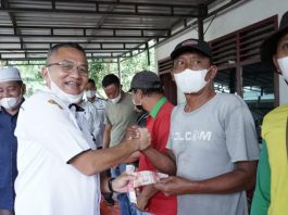 Kadis Lingkungan Hidup Kabupaten Asahan menyerahkan bantuan secara simbolis kepada Petugas Kebersihan Dinas Lingkungan Hidup Kabupaten Asahan